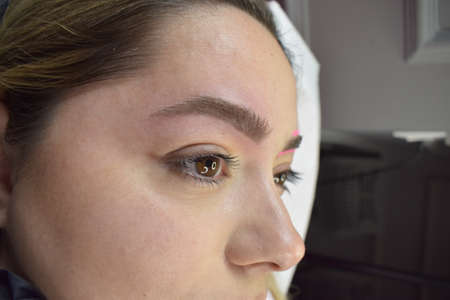 Cosmetologist who applies permanent eyebrow make-up to a young girlの写真素材