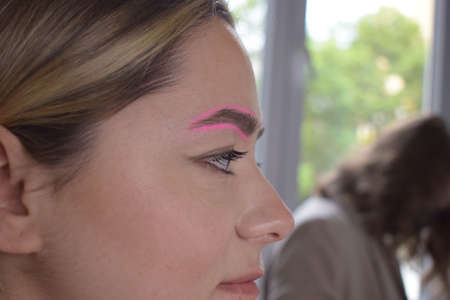 Cosmetologist who applies permanent eyebrow make-up to a young girlの写真素材