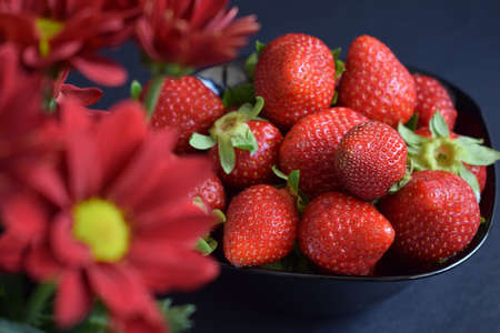 A ration of fresh strawberries on a black backgroundの写真素材