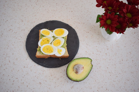 Healthy breakfast toast with egg, avocado and herbsの写真素材