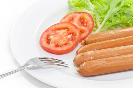 Sausage with vegetables inplate with forkの写真素材