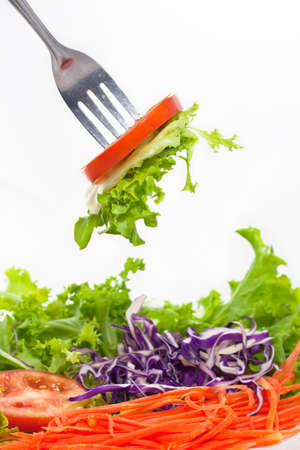 Eating vegetables salad by fork