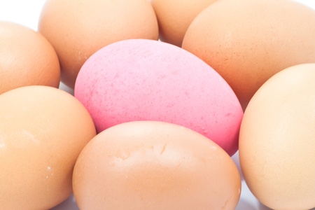 A Pink egg surrounded by the other simply eggの写真素材