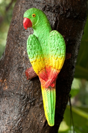 Parrot Bird made from stucco decoration on a tree in the garden