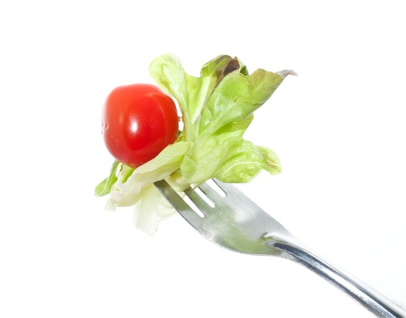 Tomato and organic vegetable salad on fork on white backgroundの写真素材
