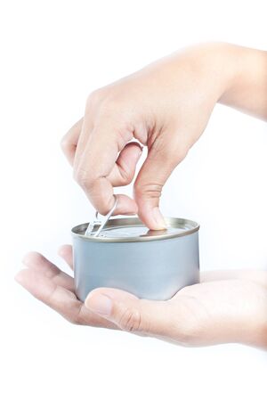 Hand  going to  open the  tuna  can on white backgroundの写真素材