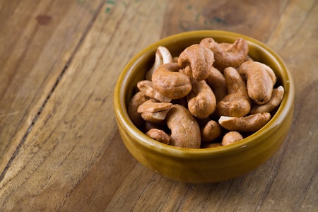 Roasted Cashews in ab owl on wood tableの写真素材