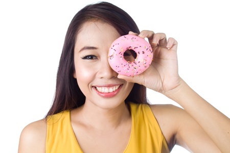 Young asian woman smiling with sweet colorful donut on white backgroundの写真素材