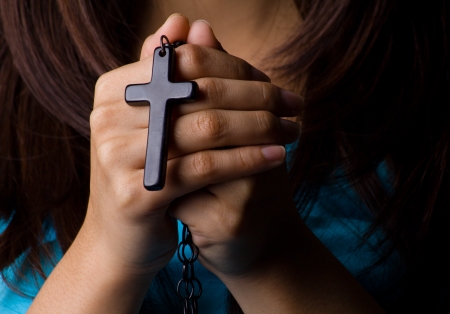 Young woman  praying with rosary in handの写真素材