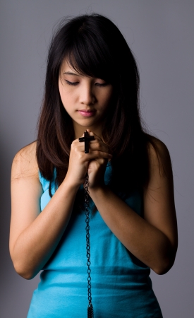 Young woman  praying with rosary in handの写真素材