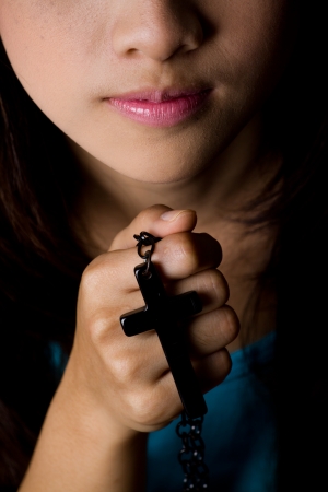 Young woman  praying with rosary in handの写真素材