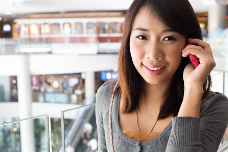 Young woman talking on mobile phone  in shopping mallの写真素材