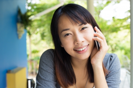 Young girl using mobile phone in the cafe restaurantの写真素材