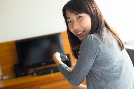 Woman with remote control switching channels