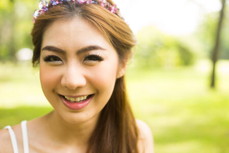 Portrait of young beautiful woman smiling in the parkの写真素材
