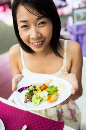Young girl  eating vegetables  saladの写真素材