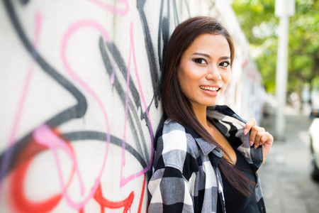 Beautiful young woman walking down the street in the cityの写真素材
