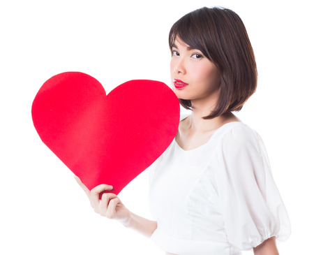 Young happy woman holding red heart. Isolated on white backgroundの写真素材