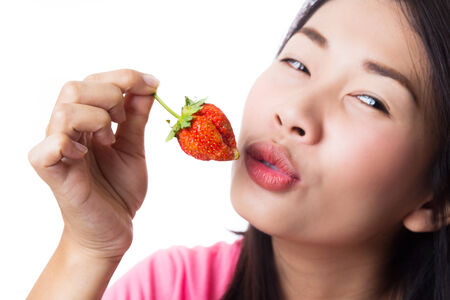 Young woman eating fresh strawberry.の写真素材