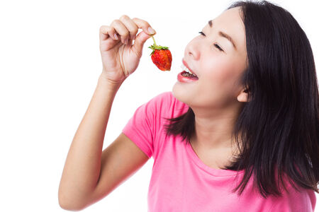 Young woman eating fresh strawberry.の写真素材