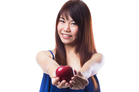 Young woman holding an apple against white backgroundの写真素材