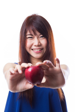 Young woman holding an apple against white backgroundの写真素材
