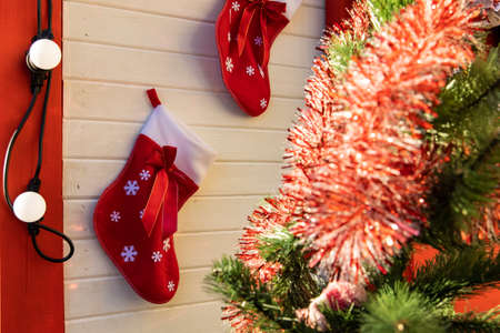 Christmas time house porch exterior decoration with red sock on wall and tree colorful toysの写真素材
