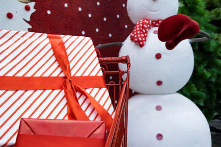 Christmas gift in shopping mall trolley with snowman background winter holidays timeの写真素材