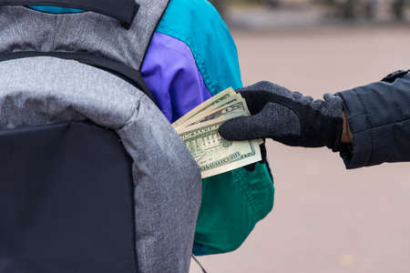 pocket theft cash money from bag crime man and victim woman incognito people criminal concept street photographyの写真素材