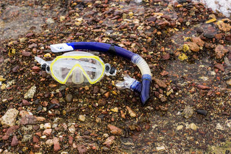 snorkeling set equipment mask and tube on beach rocky stone outdoor background near waterの写真素材
