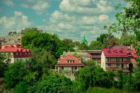 old European city outskirts district landmark view of small beautiful villa buildings in park outdoor natural zone, spring time blossom season cloudscape backgroundの写真素材