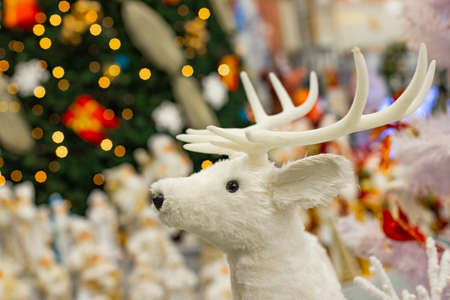 Christmas background picture decorative white deer toy on bright Christmas tree lights winter holidays background pictureの写真素材