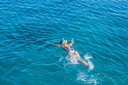 aerial view swimming girl in Red sea clear blue waters summer time vacation concept wallpaper banner with empty copy space for textの写真素材