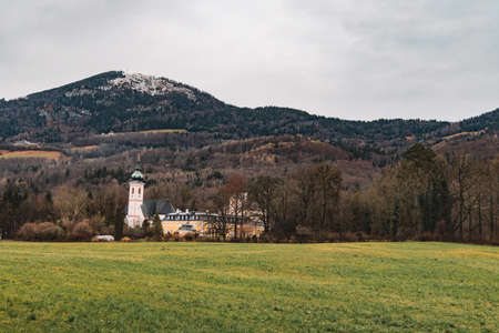 Central European country side autumn dramatic scenic view with field church and monastery buildings on Alps mountains backgroundの写真素材
