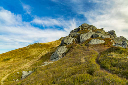 spring time season clear weather day in highland mountain green grass meadow with rocky stone top of peakの写真素材