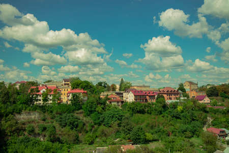 European village idyllic spring time season colorful view houses in green area with trees on blue sky white clouds background spaceの写真素材