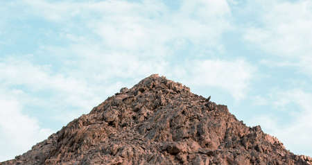 small mountain pile of stones symmetry simple scenic landscape on blue sky background spaceの写真素材
