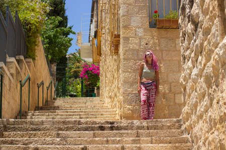 landmark travel photography of Jerusalem old city district stairs alley way stone buildings and posing young girl portrait in springの写真素材