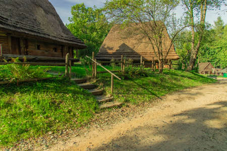 picturesque Ukrainian village rural country side landmark view with wooden cabins surrounded by spring time blossom sunny nature environmentの写真素材
