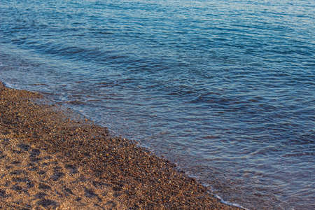 idyllic empty beach background landscape without people of crushed stone and ocean calm water scenic simple viewの写真素材