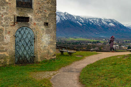travel photography in Central European region near medieval castle destination site with snowy mountain ridge peaks landscape background and womanの写真素材