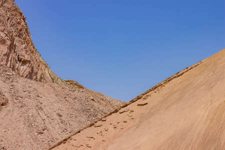 desert rocky sand stone hills frame and blue sky background wallpaper pattern dry scenic landscape with empty space for copyの写真素材