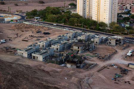 aerial photography of industrial construction building process with living houses concrete skeletons and tractors objectsの写真素材