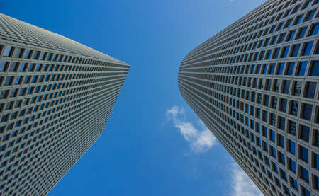 skyscraper construction buildings modern city center towers gray wall exterior architecture object foreshortening from below on blue sky background copy spaceの写真素材