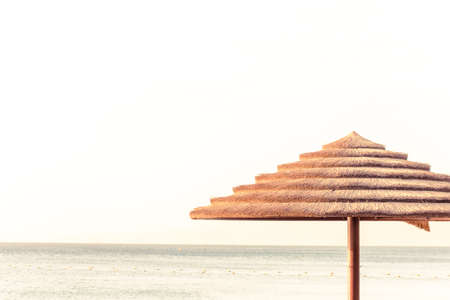 summer time vacation season poster wallpaper pattern beach scenery landscape straw umbrella foreground horizon sea view background with empty copy space for your textの写真素材