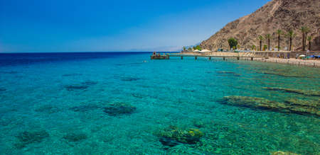 paradise Red sea Israeli coral beach tropic scenery landscape with pier above water and fun people, summer season vacation panorama photographyの写真素材
