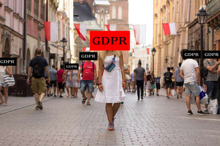 GDPR privacy regulation law in European Union concept photography of beautiful Ukrainian girl portrait walking in Krakow medieval city street center between peopleの写真素材