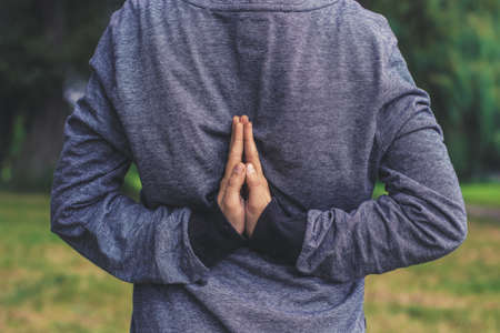 concept shot of prayer person hold hands near each other with hoody clothes upside down and face hide behind hoodの写真素材