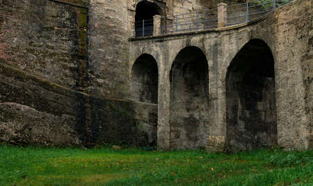 old architecture castle exterior stone walls and arch shape of bridge building object green grass meadow foregroundの写真素材