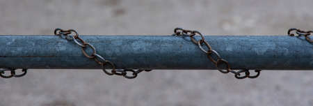 iron pipe rusty chains around horizon picture concept of fenced industry area with blurred...